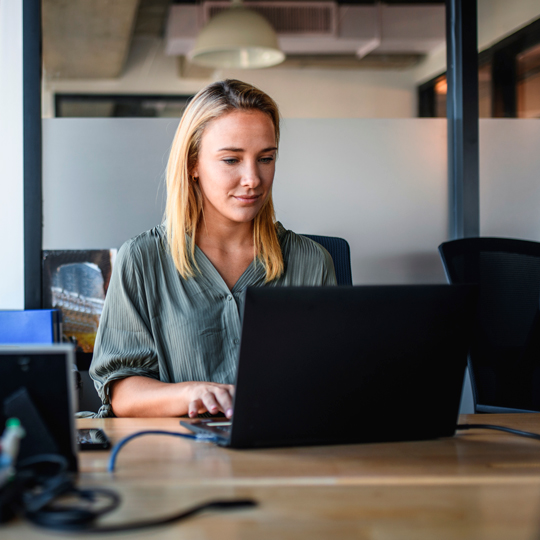 Woman working on a laptop in an office setting